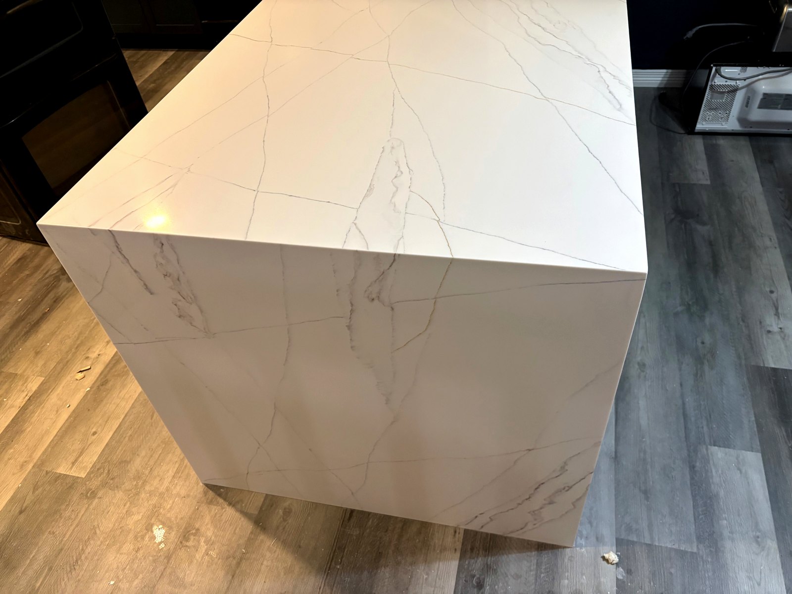 Mitered Waterfall Edge — Precision mitered edge detail on a Calacatta-style quartz island